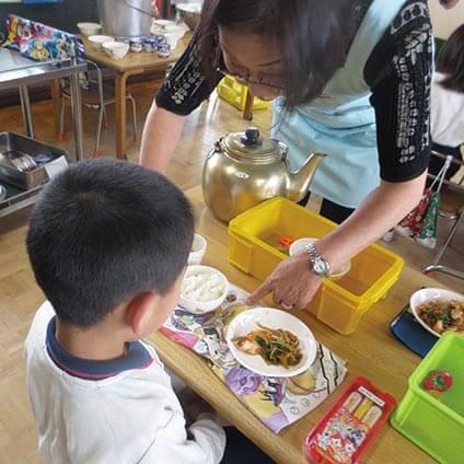 配膳する園長先生